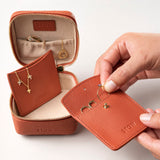 STOW Leather Hester Jewellery Case in Clay Orange colour, open showing two leather sleeves inside (included with case) and an assortment of jewellery.