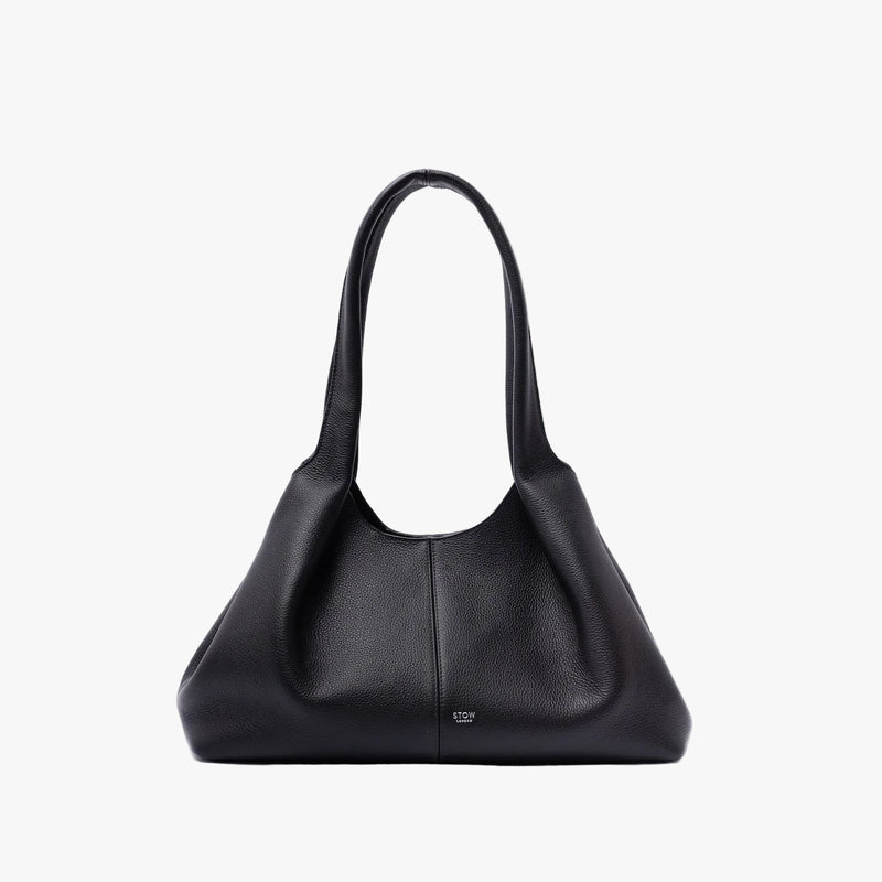 STOW London's Hobo Tote in Black pebbled leather on a light grey background in its triangular hobo shape featuring a pleated front panel and small silver embossed logo