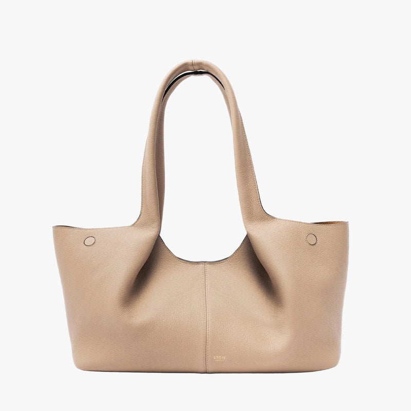 STOW London's Hobo Tote in Camel pebbled leather on a light grey background featuring a pleated front panel and small gold embossed logo