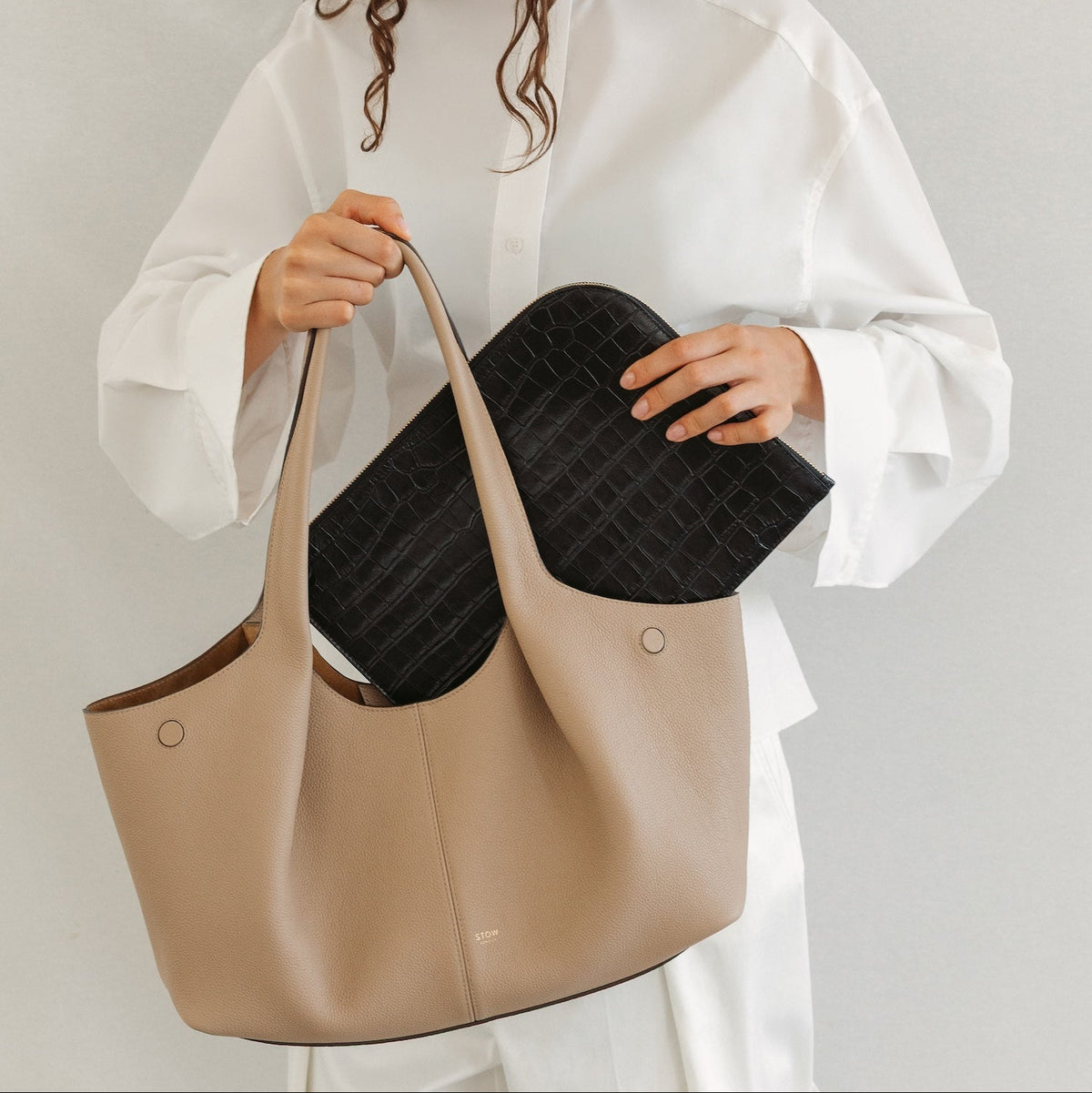 Model with STOW London's Hobo Tote in Camel pebbled leather featuring a pleated front panel and the Midi Leather Sleeve in Black Embossed Croc