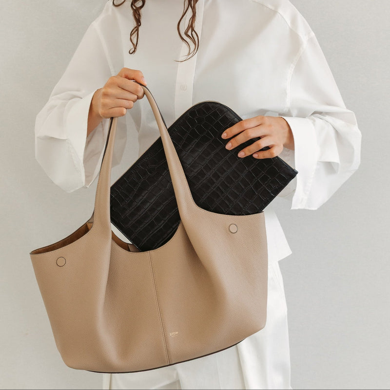 Model with STOW London's Hobo Tote in Camel pebbled leather featuring a pleated front panel and the Midi Leather Sleeve in Black Embossed Croc