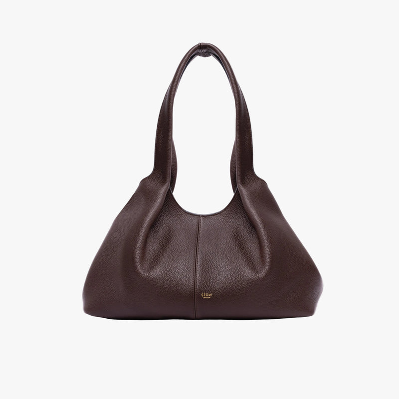 STOW London's Hobo Tote in Espresso pebbled leather in its triangular hobo form on a light grey background featuring a pleated front panel and small gold embossed logo