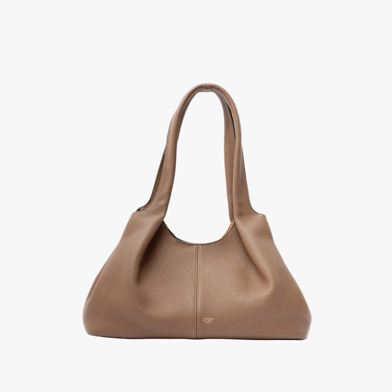 STOW London's Hobo Tote in Mocha pebbled leather in its triangular hobo form on a light grey background featuring a pleated front panel and small gold embossed logo