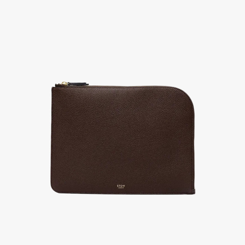 STOW London's Ipad Sleeve in Espresso pebbled leather on a light grey background featuring a YKK Natulon Zip and a fine gold embossed logo on the front bottom. 