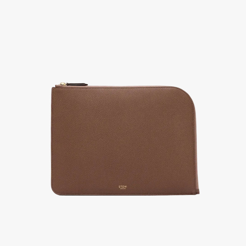STOW London's Ipad Sleeve in Mocha pebbled leather on a light grey background featuring a YKK Natulon Zip and a fine gold embossed logo on the front bottom. 
