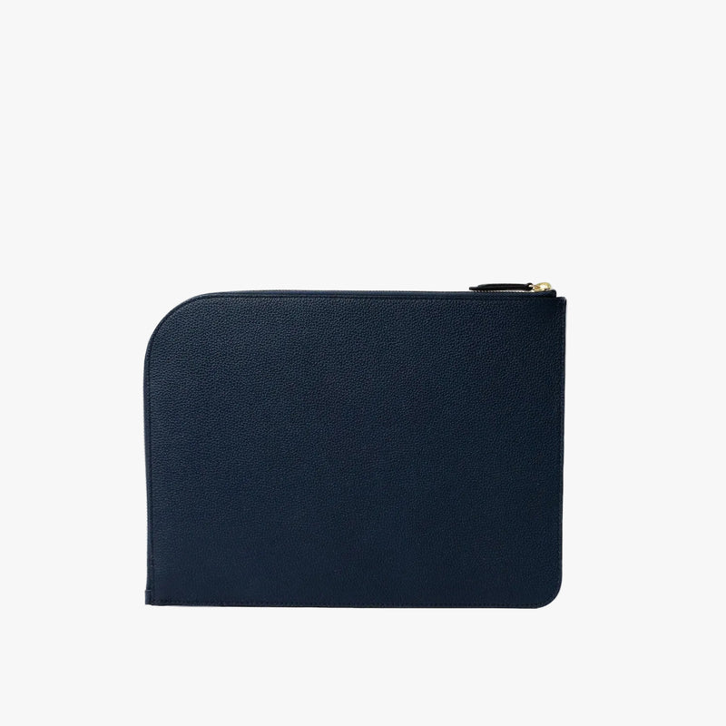 Back panel of STOW London's Ipad Sleeve in Navy pebbled leather on a light grey background featuring a YKK Natulon Zip closure