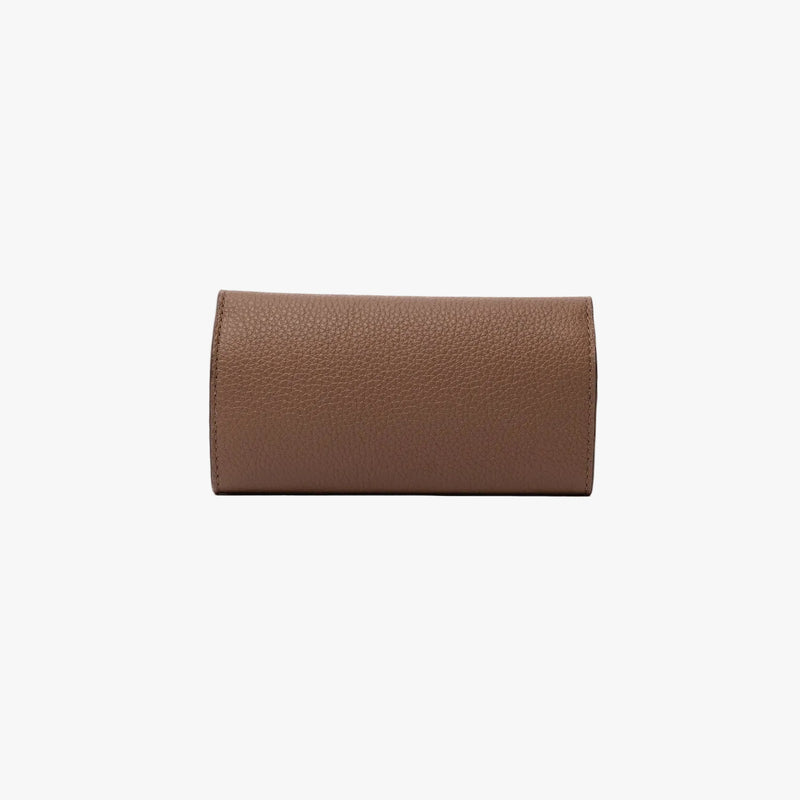 Back panel of STOW London's Jewellery Roll in Mocha pebbled leather on a light grey background