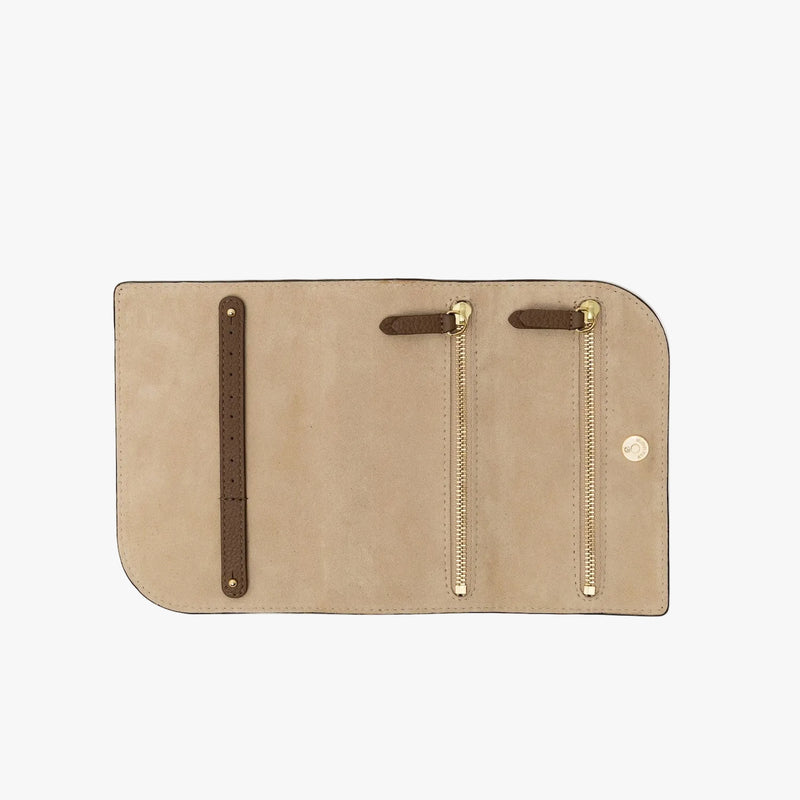 STOW London's Jewellery Roll in Mocha pebbled leather on a light grey background rolled out showing the light suede interior lining, two zip pockets and a leather strap