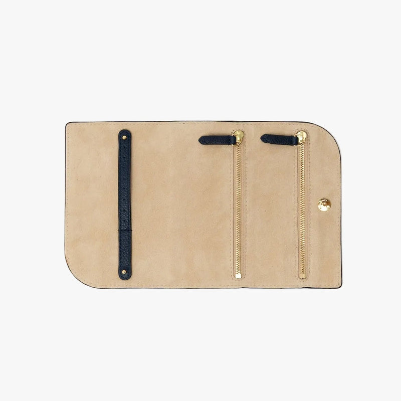 STOW London's Jewellery Roll in Navy pebbled leather on a light grey background rolled out showing the light suede interior featuring two zip pockets and leather strap