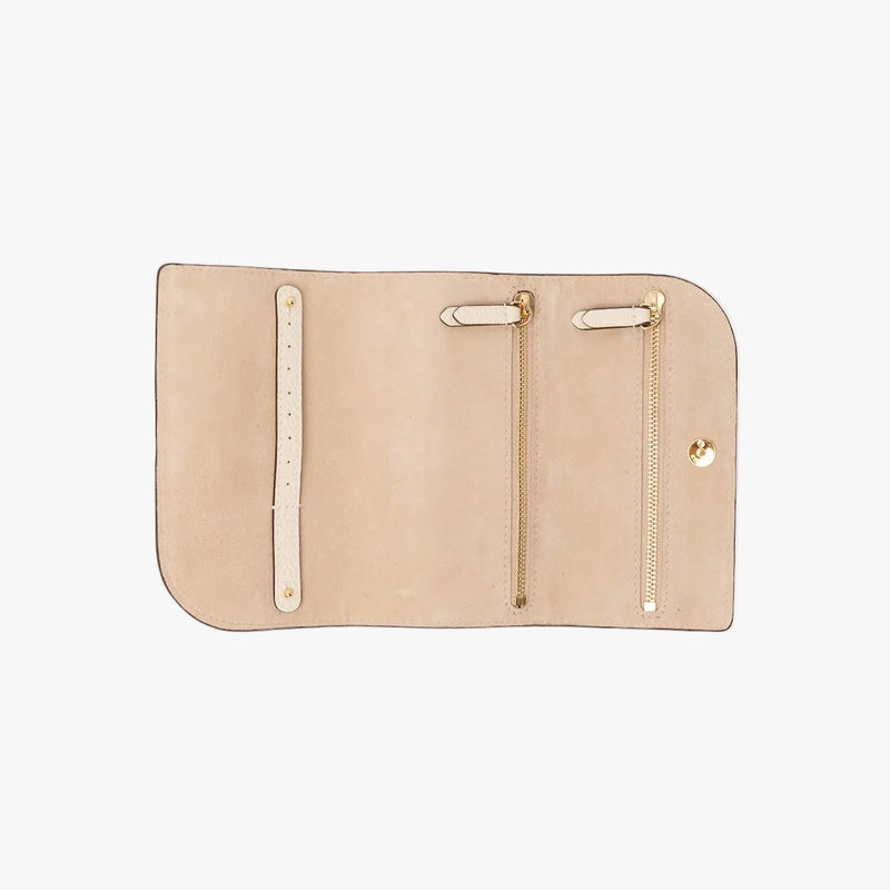 STOW London's Jewellery Roll in Spring Moon pebbled leather on a light grey background rolled out showing the light suede interior featuring two zip pockets and leather strap