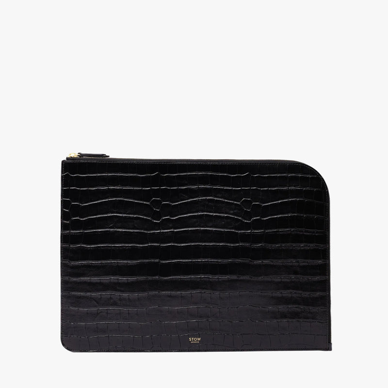 STOW London's Leather Sleeve in Black Embossed Croc leather on a light grey background featuring a YKK Natulon Zip and a fine gold embossed logo on the front bottom. 