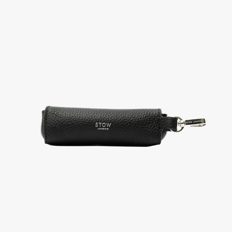 STOW London's Lipstick Case in Black pebbled leather featuring a silver stainless steel clip and embossed logo on a light grey background