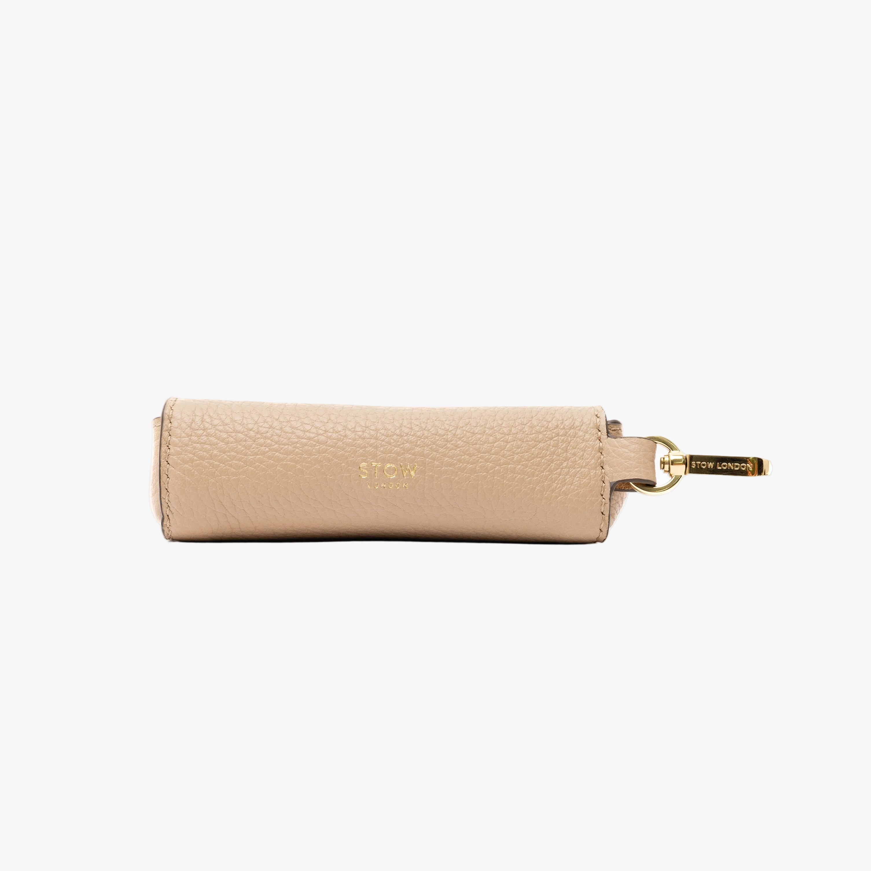 STOW London's Lipstick Case in Camel pebbled leather on a light grey background featuring gold-coated stainless steel hardware