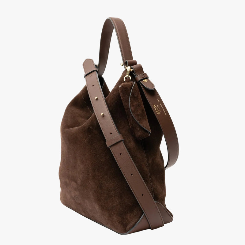 STOW London's Lipstick Case in Chocolate suede leather attached to the matching Curve bag on a light grey background featuring a gold-coated stainless steel clip