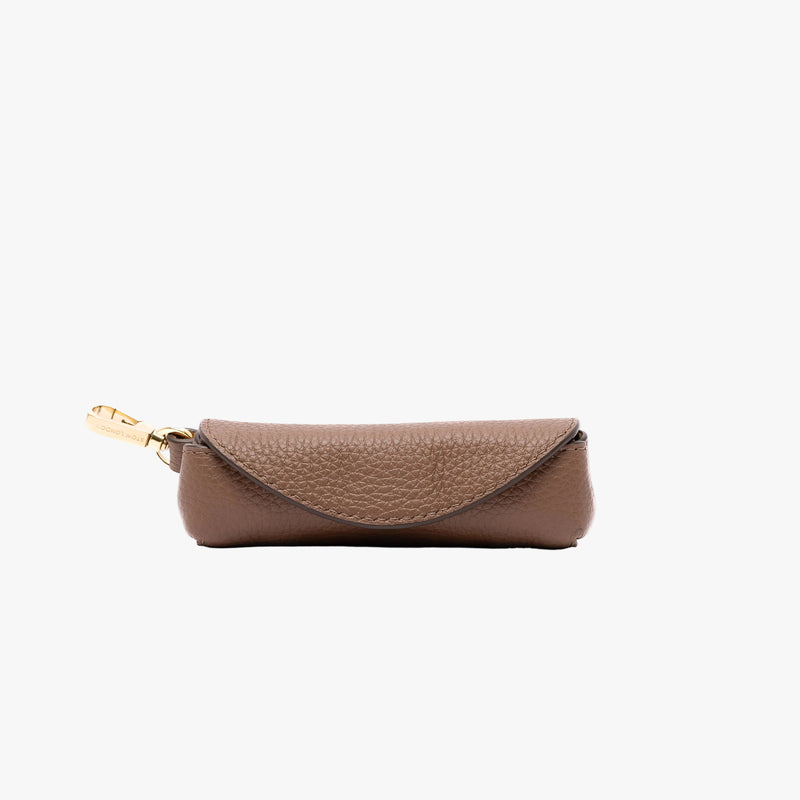 STOW London's Lipstick Case in Mocha pebbled leather on a light grey background featuring gold-coated stainless steel hardware