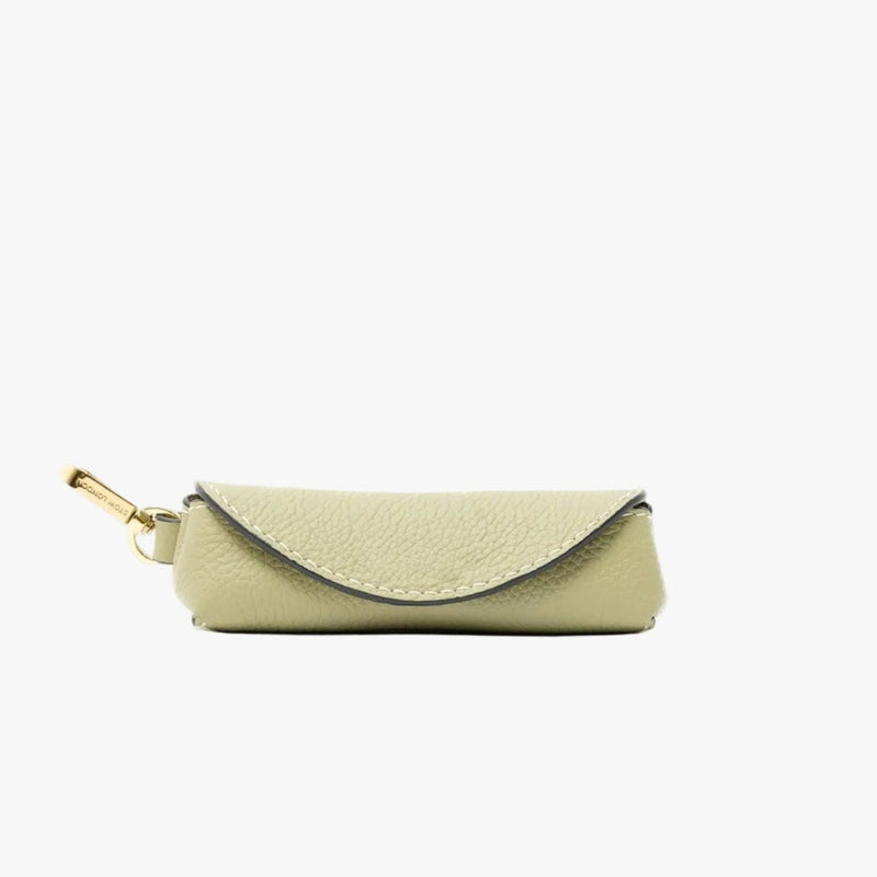 STOW London's Lipstick Case in Pale Green pebbled leather featuring a gold-coated stainless steel clip on a light grey background