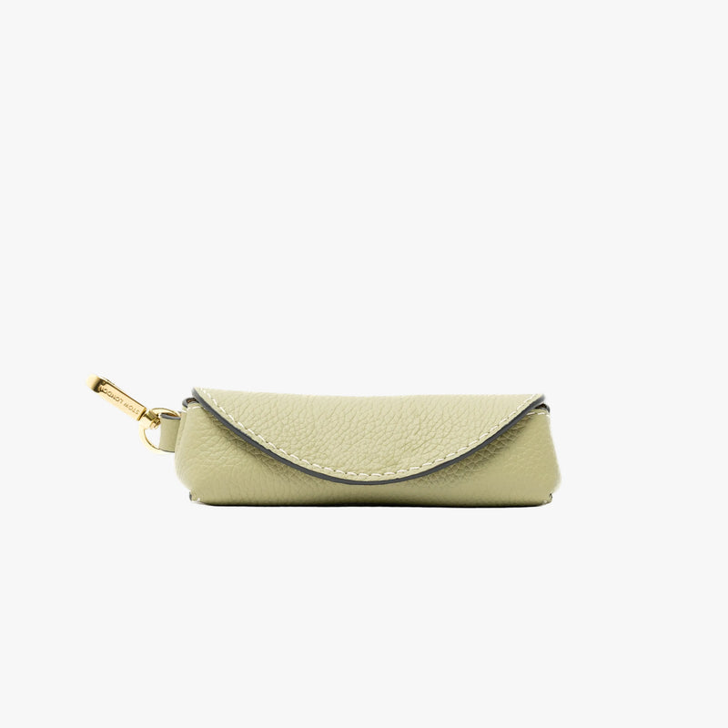 STOW London's Lipstick Case in Pale Green pebbled leather featuring a gold-coated stainless steel clip on a light grey background