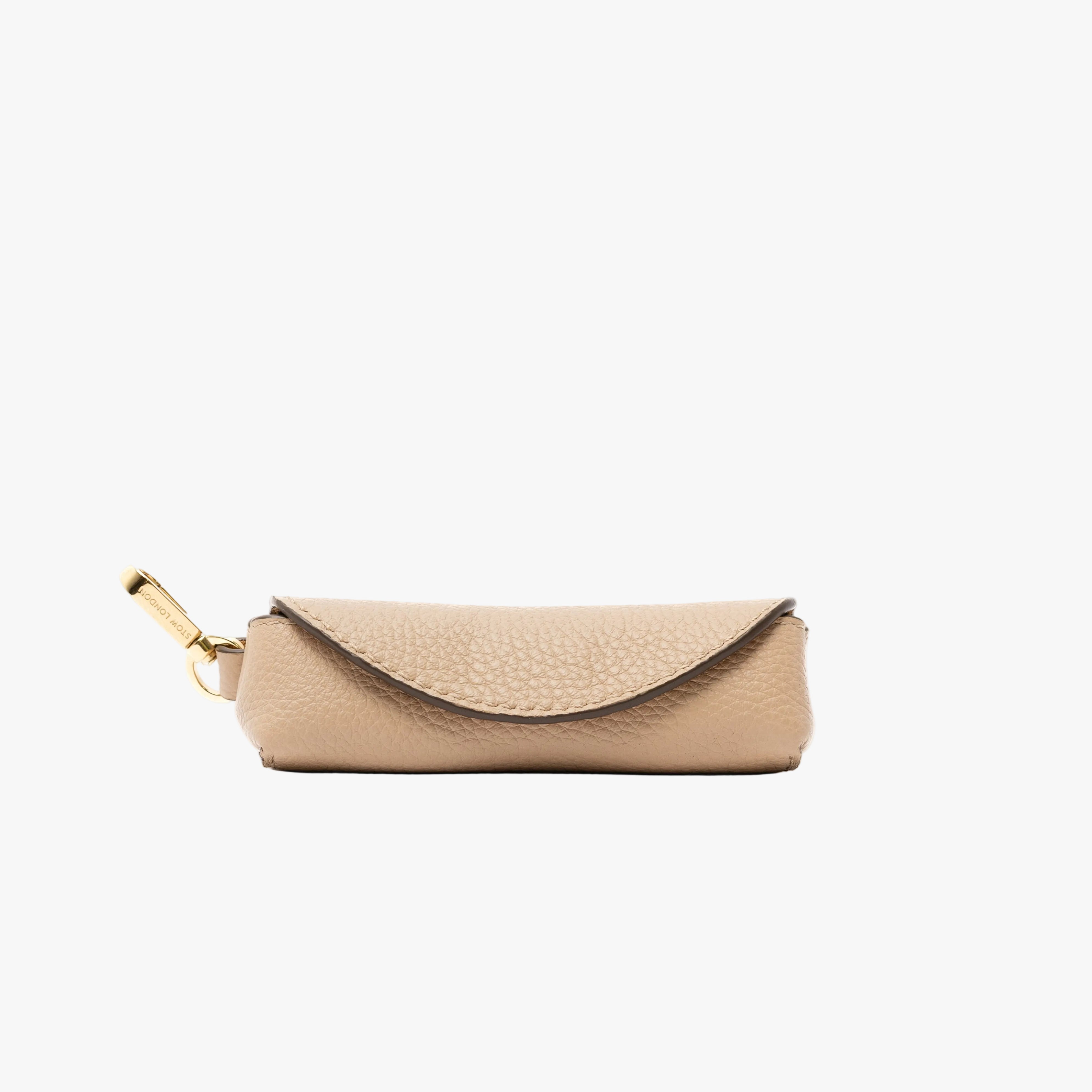 STOW London's Lipstick Case in Camel pebbled leather featuring a gold-coated stainless steel clip on a light grey background