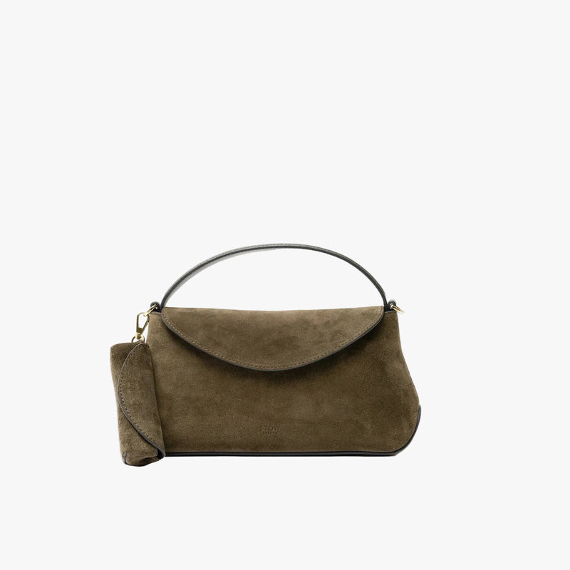 STOW London's Lipstick Case in Dark Green Suede leather attached by a gold-coated stainless steel clip to the matching Mini East West bagon a light grey background