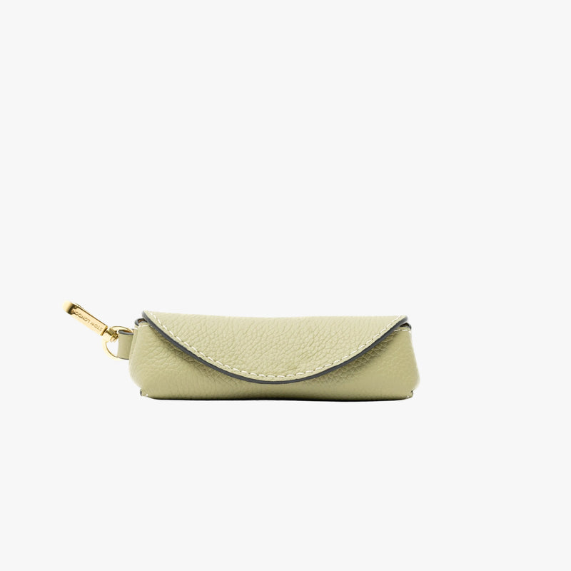 STOW London's Lipstick Case in Pale Green pebbled leather featuring a gold-coated stainless steel clip on a light grey background