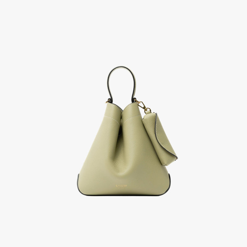 STOW London's Lipstick Case  in Pale Green pebbled leather attached to the matching Mini Curve featuring a gold-coated stainless steel clip on a light grey background