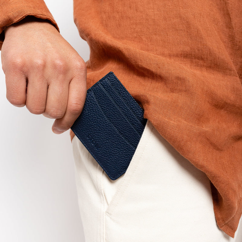 STOW London Leather Cardholder in Navy colour. Male model placing cardholder into pocket.