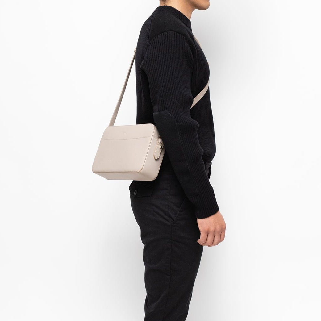 STOW London Large Camera Bag in Light Taupe leather worn by male model wearing black in studio