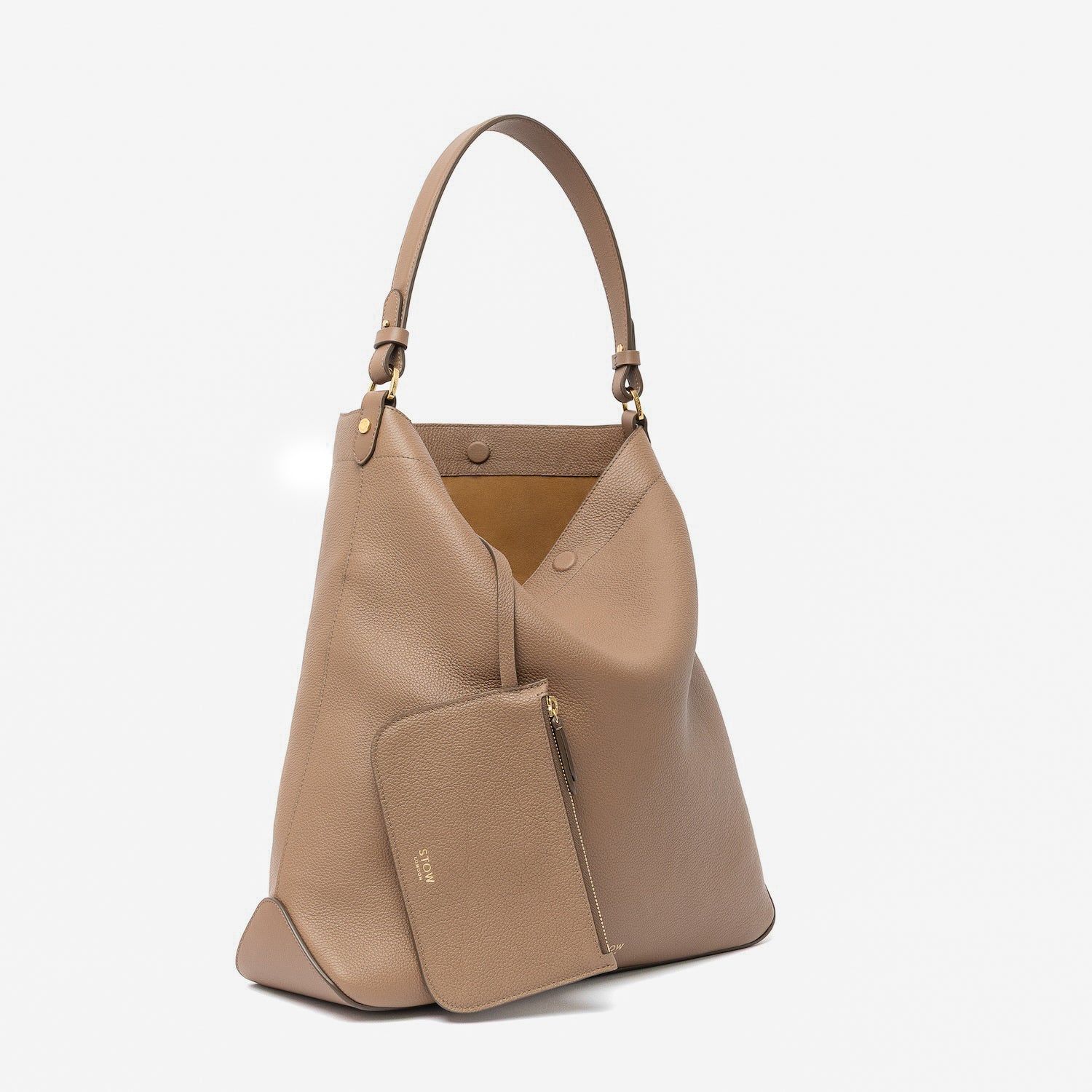 Off-axis view of STOW London's Maxi Curve bag in Mocha pebbled leather and matching, detachable interior pouch featuring gold-coated stainless steel hardware on a light grey background
