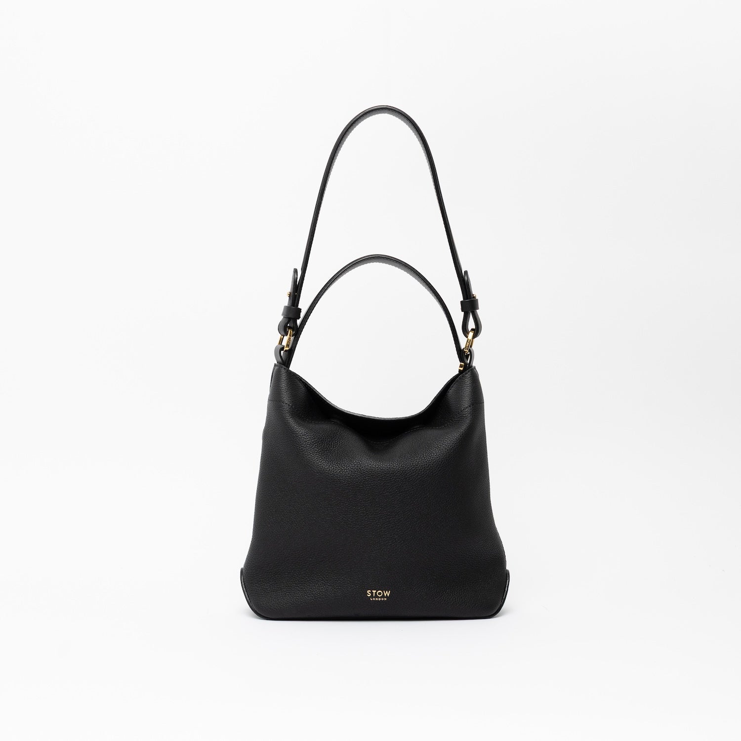 STOW London's Midi Curve and detachable shoulder strap and top handle in Black leather  out on a light grey background featuring gold hardware and details 