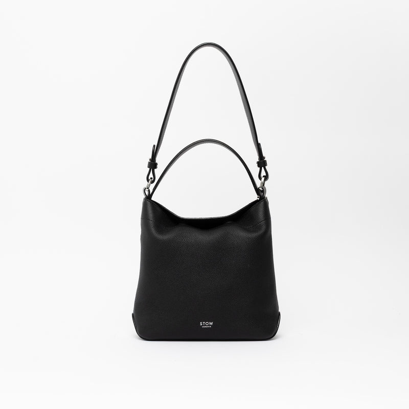 STOW London's Midi Curve and detachable shoulder strap and top handle in Black leather on a light grey background featuring silver hardware and details 