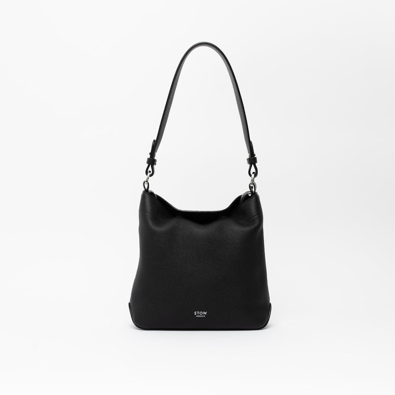 STOW London's Midi Curve and detachable shoulder strap in Black leather on a light grey background featuring silver hardware and details 