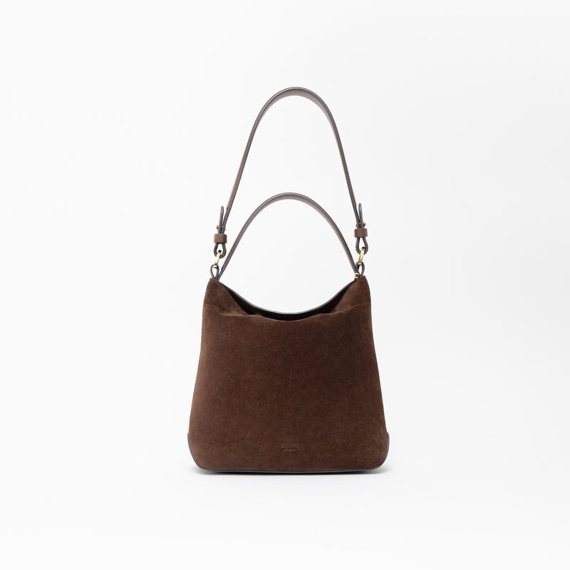STOW London's Midi Curve in Chocolate suede leather featuring the detachable shoulder strap and top handle with gold hardware 