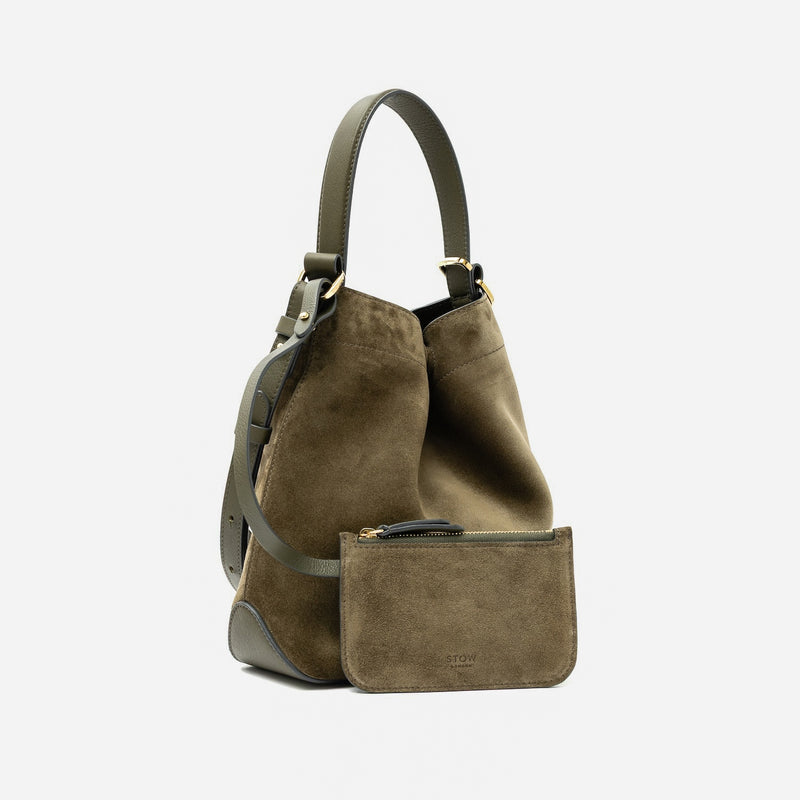STOW London's Midi Curve in Dark Green suede leather with its matching, detachable interior pouch featuring gold-coated stainless steel hardware on a light grey background