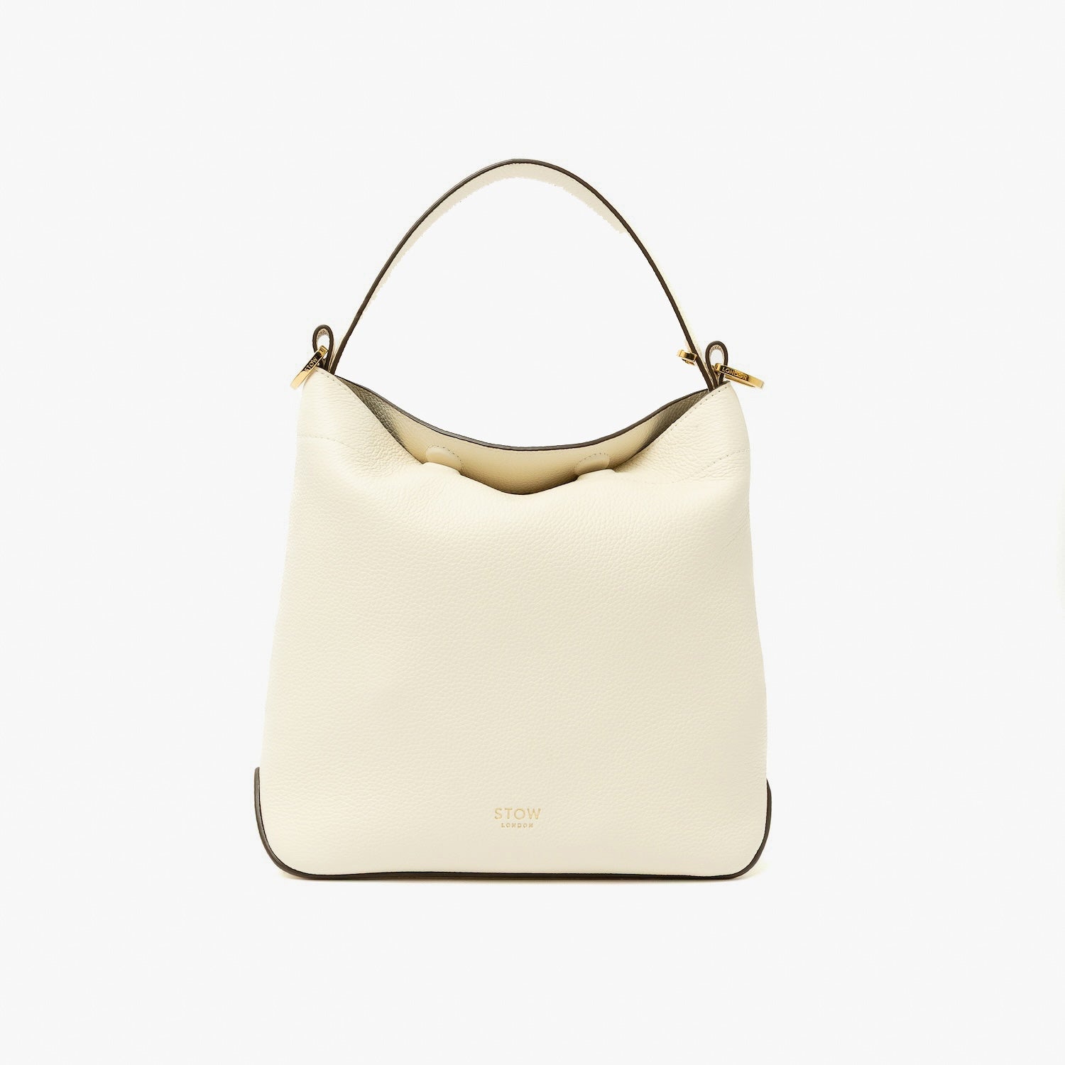 STOW London's Midi Curve in Spring Moon pebbled leather shaped as flap bag featuring gold-coated stainless steel hardware on a light grey background