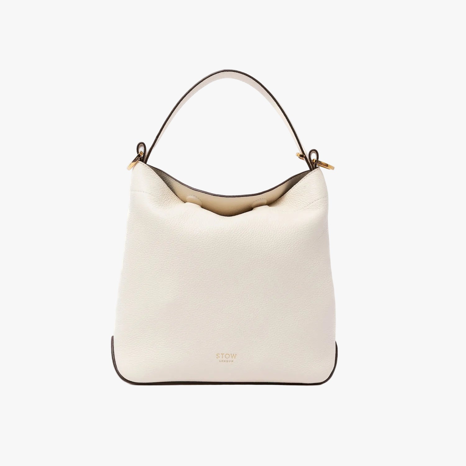 STOW London's Midi Curve in Spring Moon pebbled leather shaped as a flap bag featuring gold-coated stainless steel hardware on a light grey background