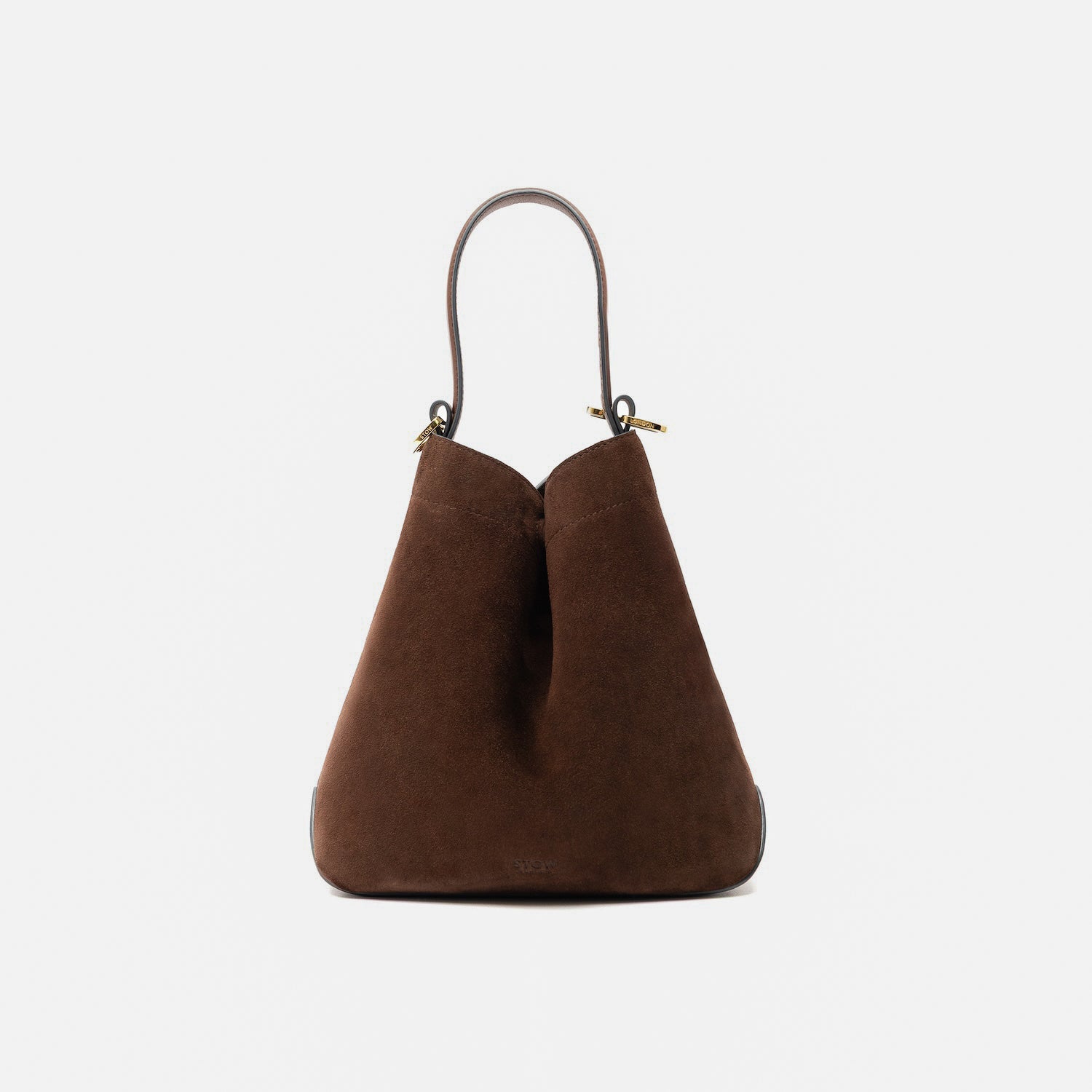 STOW London's Midi Curve in Chocolate suede leather styled in a triangular form featuring gold-coated stainless steel hardware on a light grey background