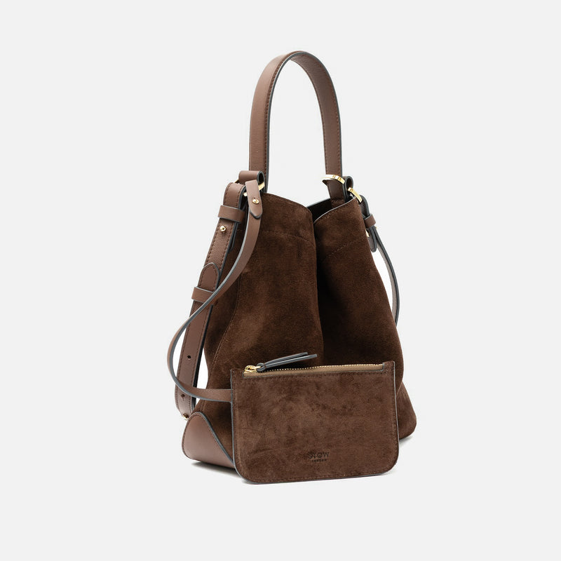STOW London's Midi Curve in Chocolate suede leather and matching, detachable interior pouch featuring gold-coated stainless steel hardware on a light grey background
