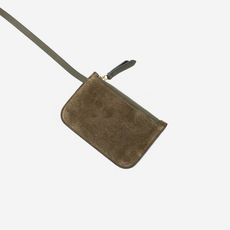 Close up of the detachable interior pouch of STOW London's Midi Curve in Dark Green suede leather featuring gold-coated stainless steel hardware on a light grey background