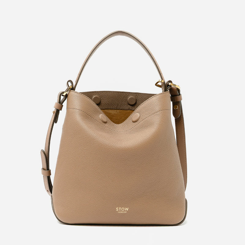 STOW London's Midi Curve in Mocha pebbled leather featuring gold-coated stainless steel hardware on a light grey background