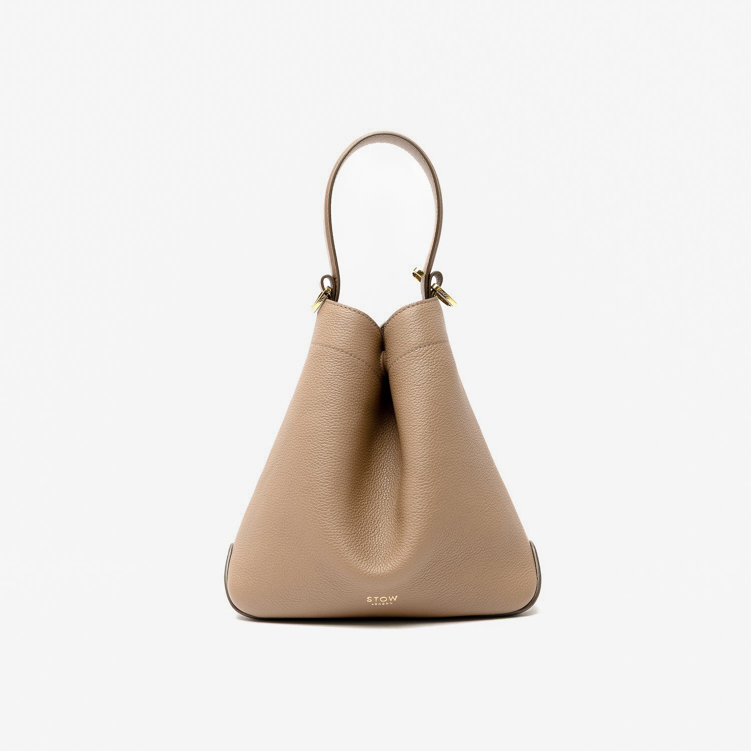 STOW London's Midi Curve in Mocha pebbled leather styled in a triangular form featuring gold-coated stainless steel hardware on a light grey background