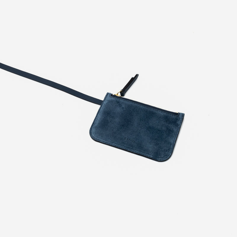 Close up of the detachable interior pouch of STOW London's Midi Curve in Navy suede leather on a light grey background
