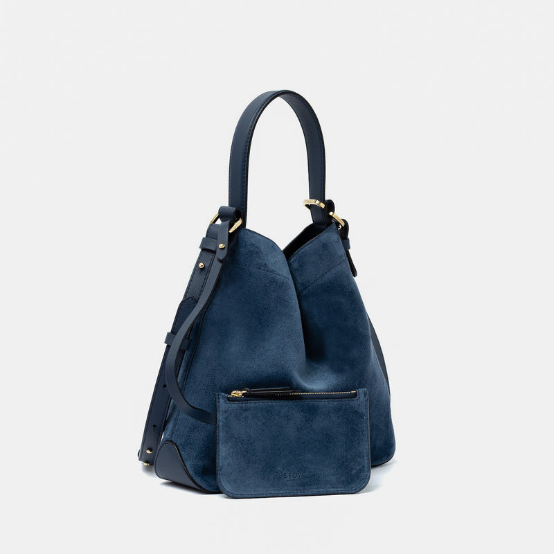 STOW London's Midi Curve in Navy suede leather with the matching, detachable interior pouch featuring gold-coated stainless steel hardware on a light grey background