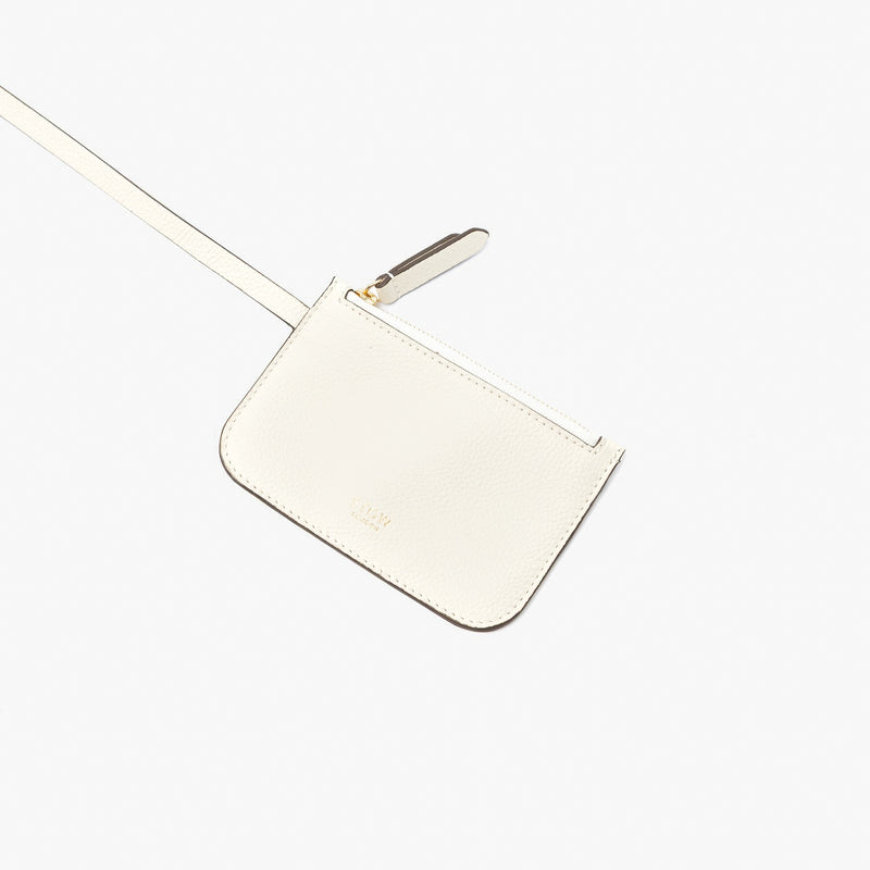 Close up of the detachable interior pouch from STOW London's Midi Curve in Spring Moon pebbled leather featuring gold-coated stainless steel hardware on a light grey background