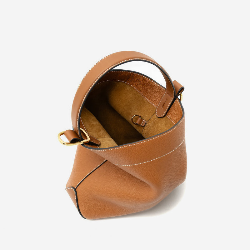 STOW London's Midi Curve in Earth Tan pebbled leather with magnets open showing suede interior and d-ring featuring gold-coated stainless steel hardware on a light grey background