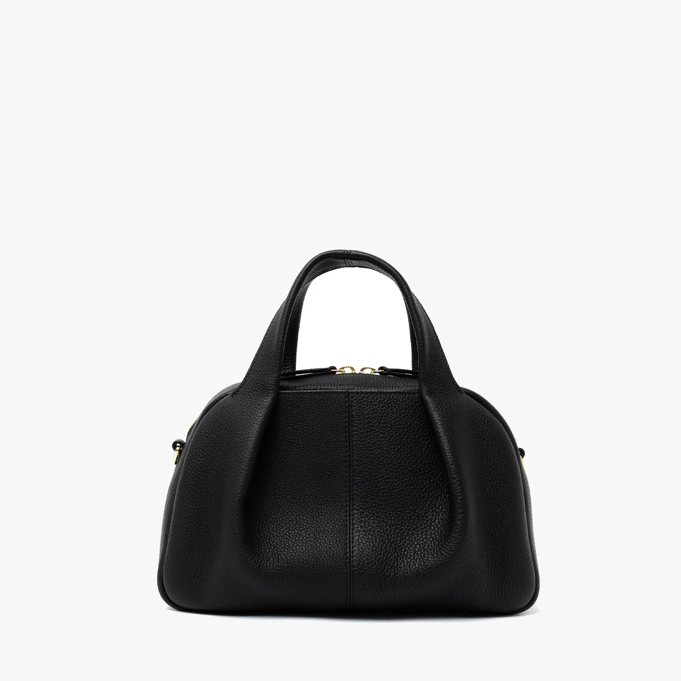 STOW London's Mini Bowling bag in Black pebbled leather featuring a pleated front panel and gold-coated stainless steel hardware on a light grey background

