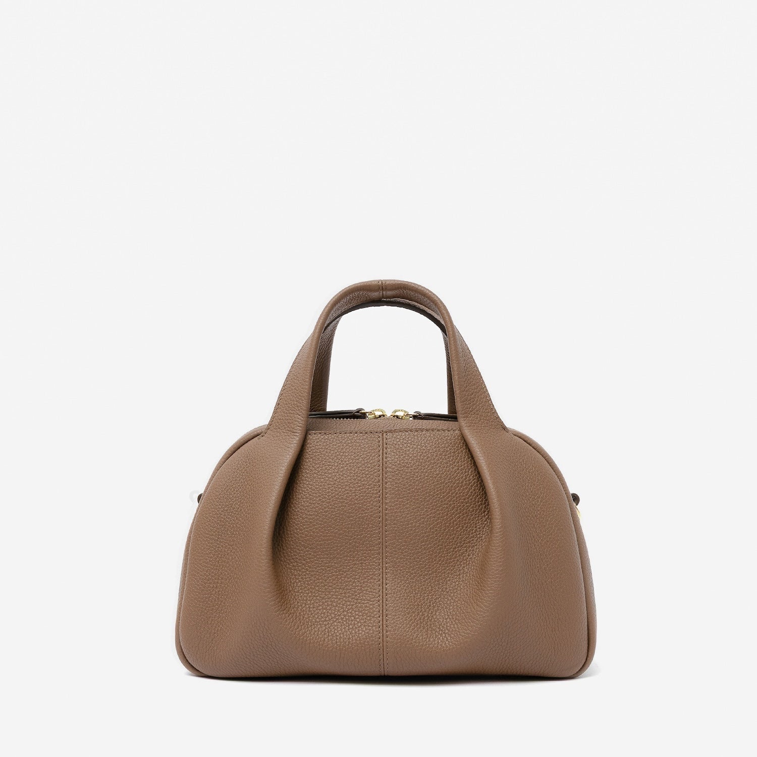 STOW London's Mini Bowling bag in Mocha pebbled leather featuring a pleated front panel and gold-coated stainless steel hardware on a light grey background