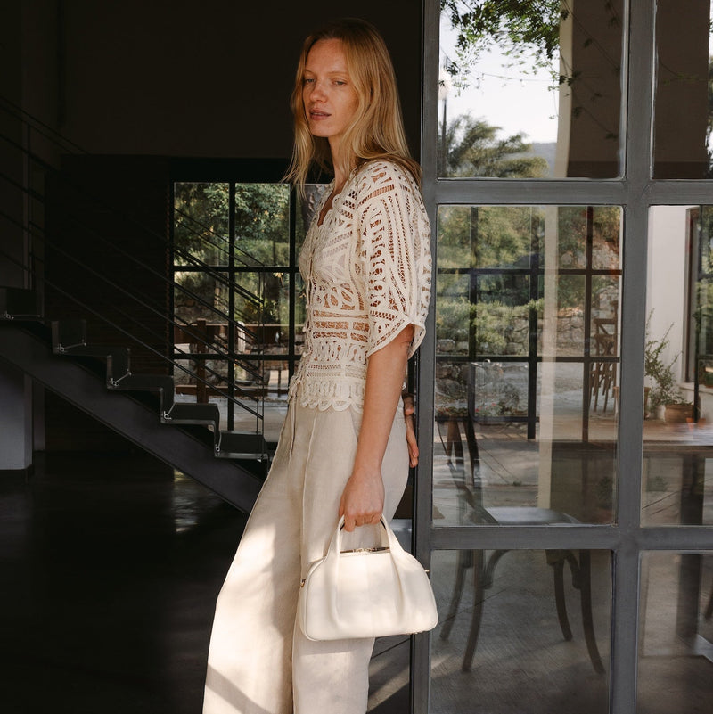 Model with STOW London's Midi Bowling  in Spring Moon pebbled leather featuring gold-coated stainless steel hardware