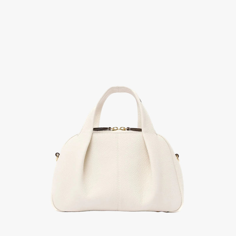 STOW London's Mini Bowling bag in Spring Moon pebbled leather featuring a pleated front panel and gold-coated stainless steel hardware on a light grey background