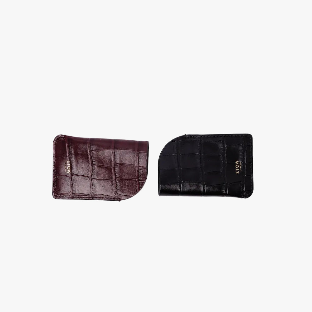 STOW London's Mini Cardholder in Black and Burgundy Embossed Croc leather on a light grey background featuring a small gold embossed logo on the front bottom