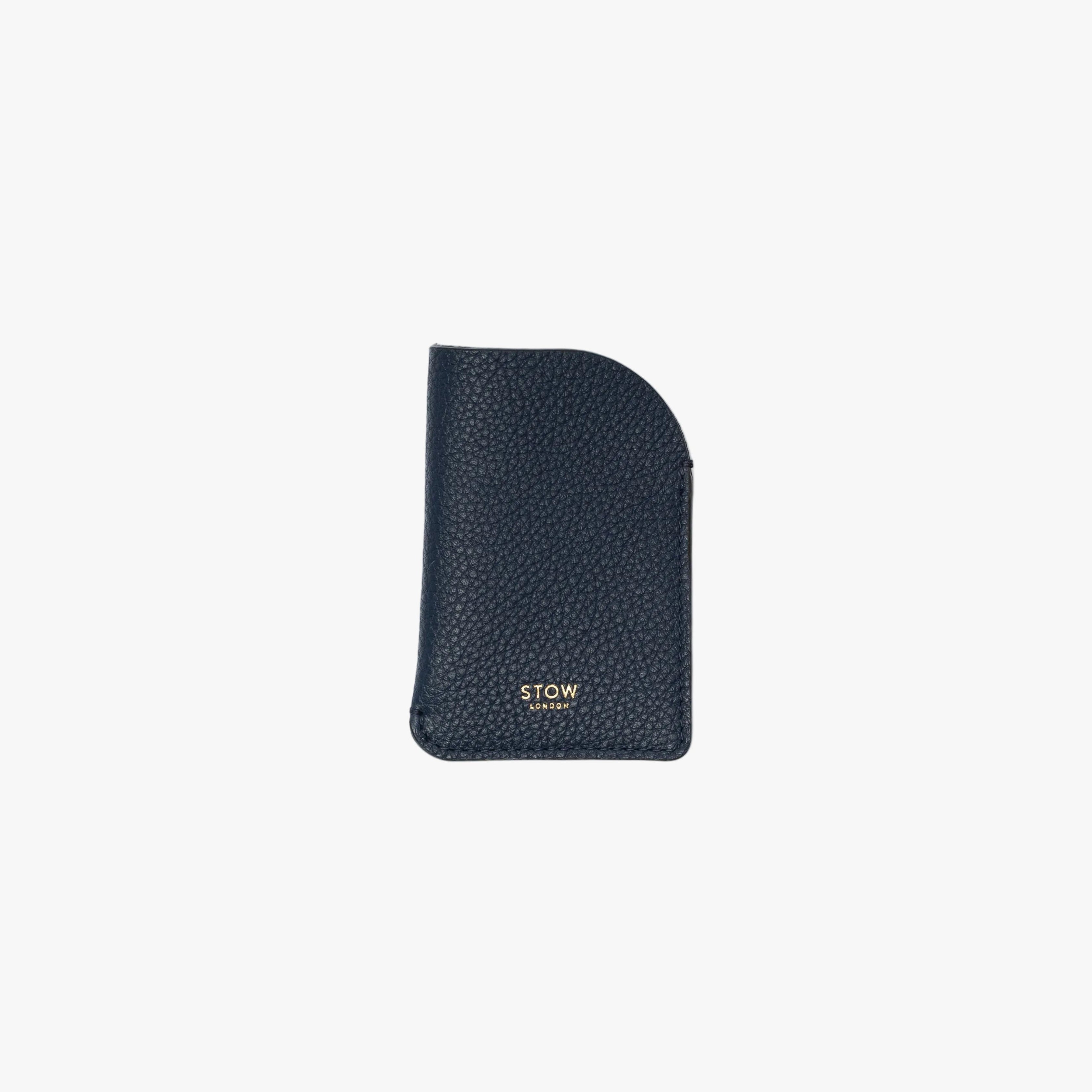 STOW London's Mini Cardholder in Navy pebbled leather on a light grey background featuring a small gold embossed logo on the front bottom